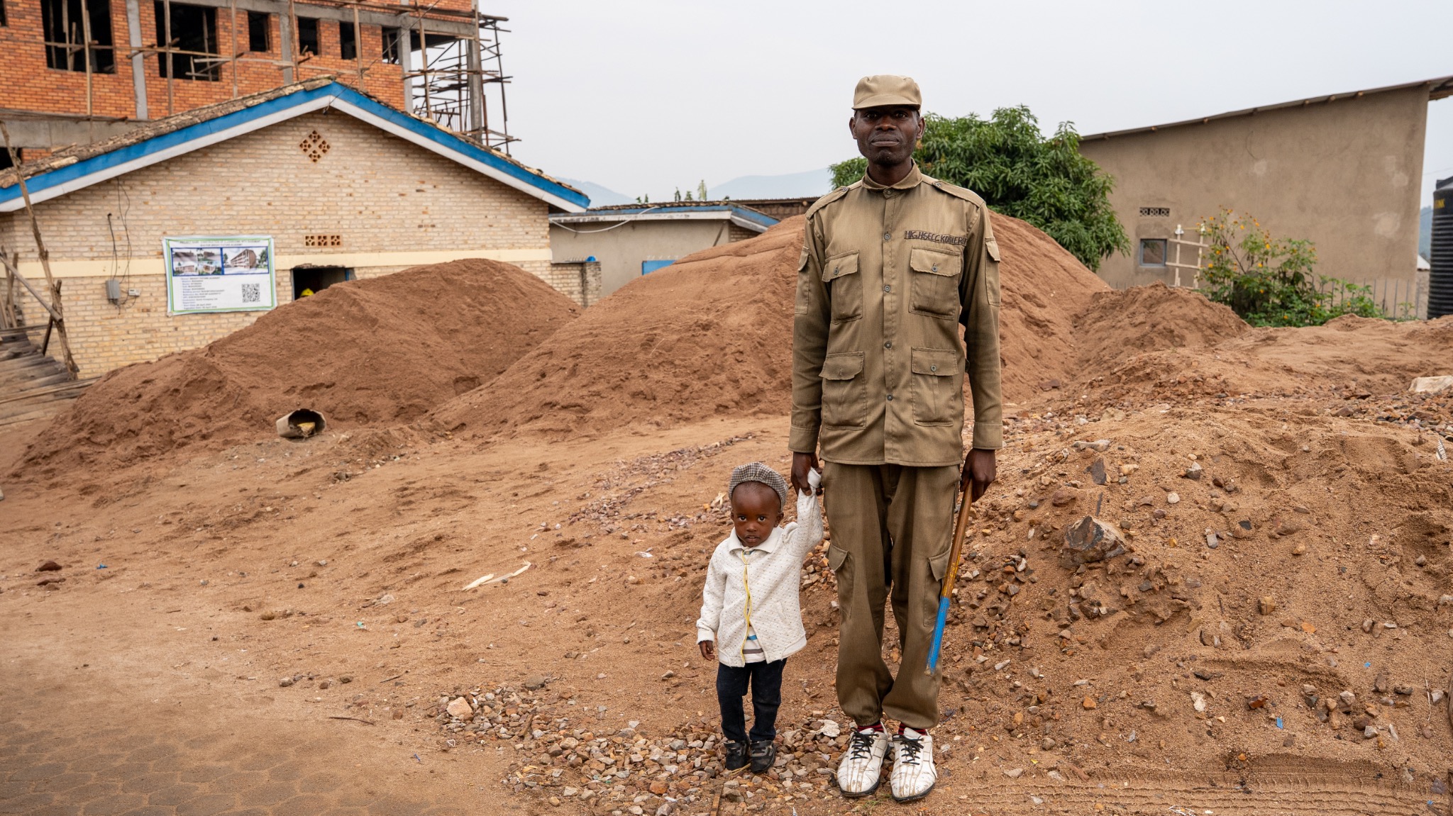 A community guard standing with a child in Rwanda